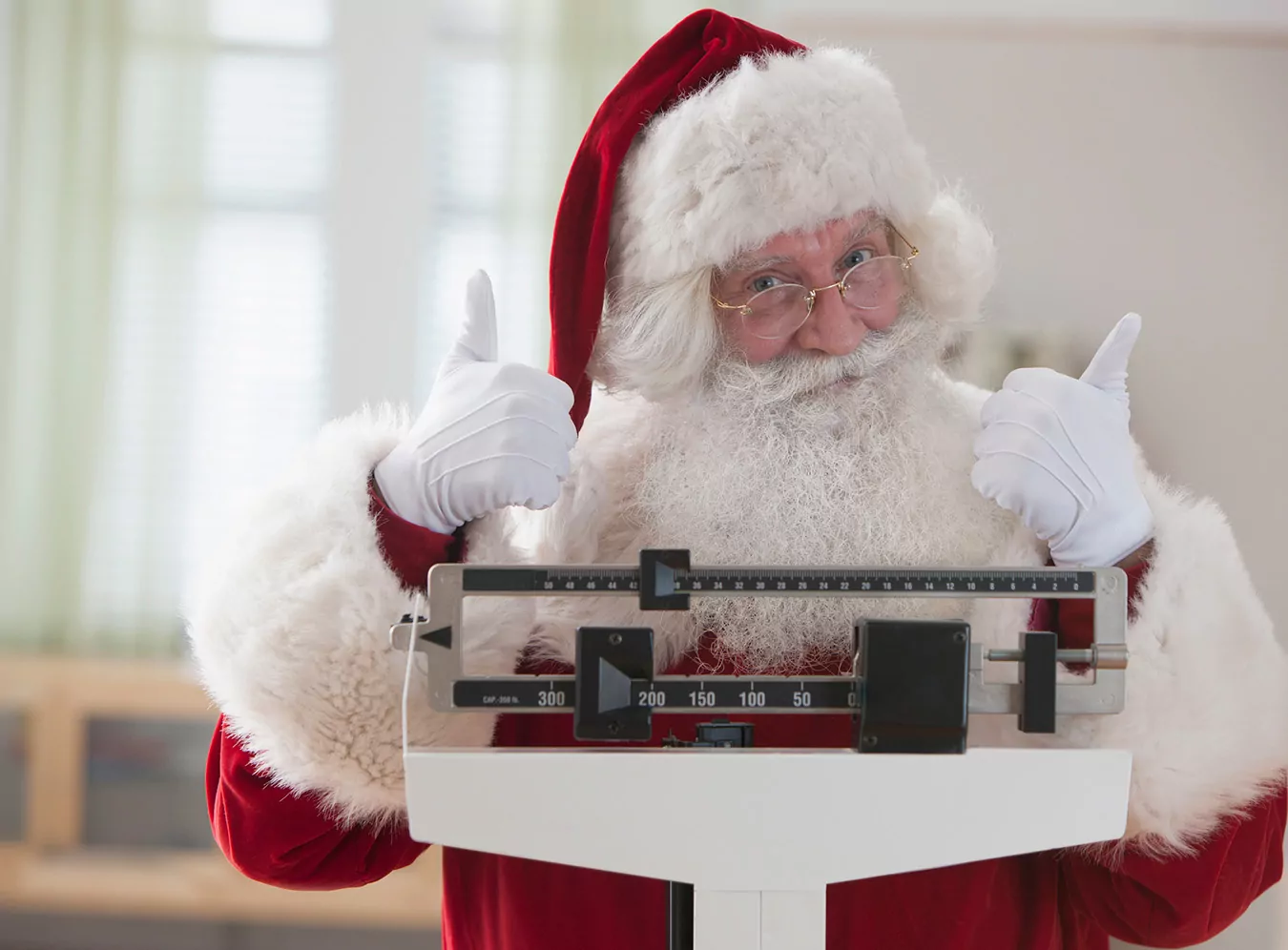 Santa standing on scale with thumbs up