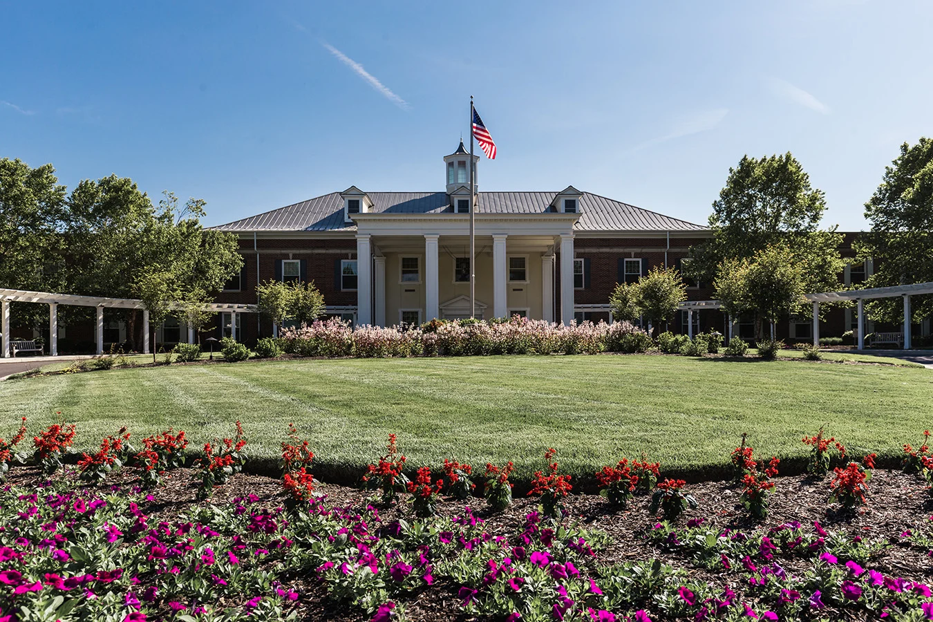 Exterior of Masonic Village at Lafayette Hill, a large building with columns and a garden in the foreground.