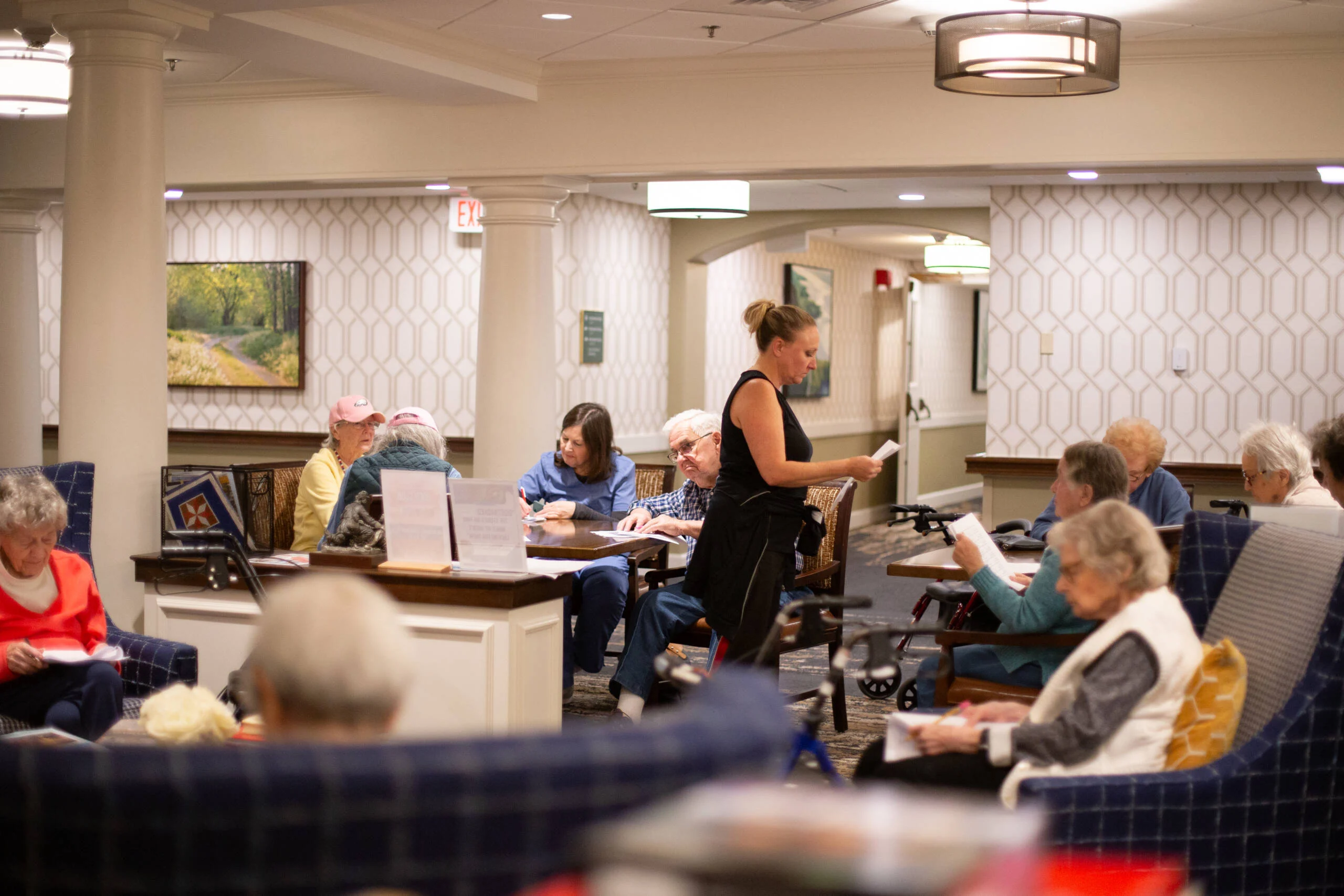 Staff member handing out papers to seated residents for balance workshop.