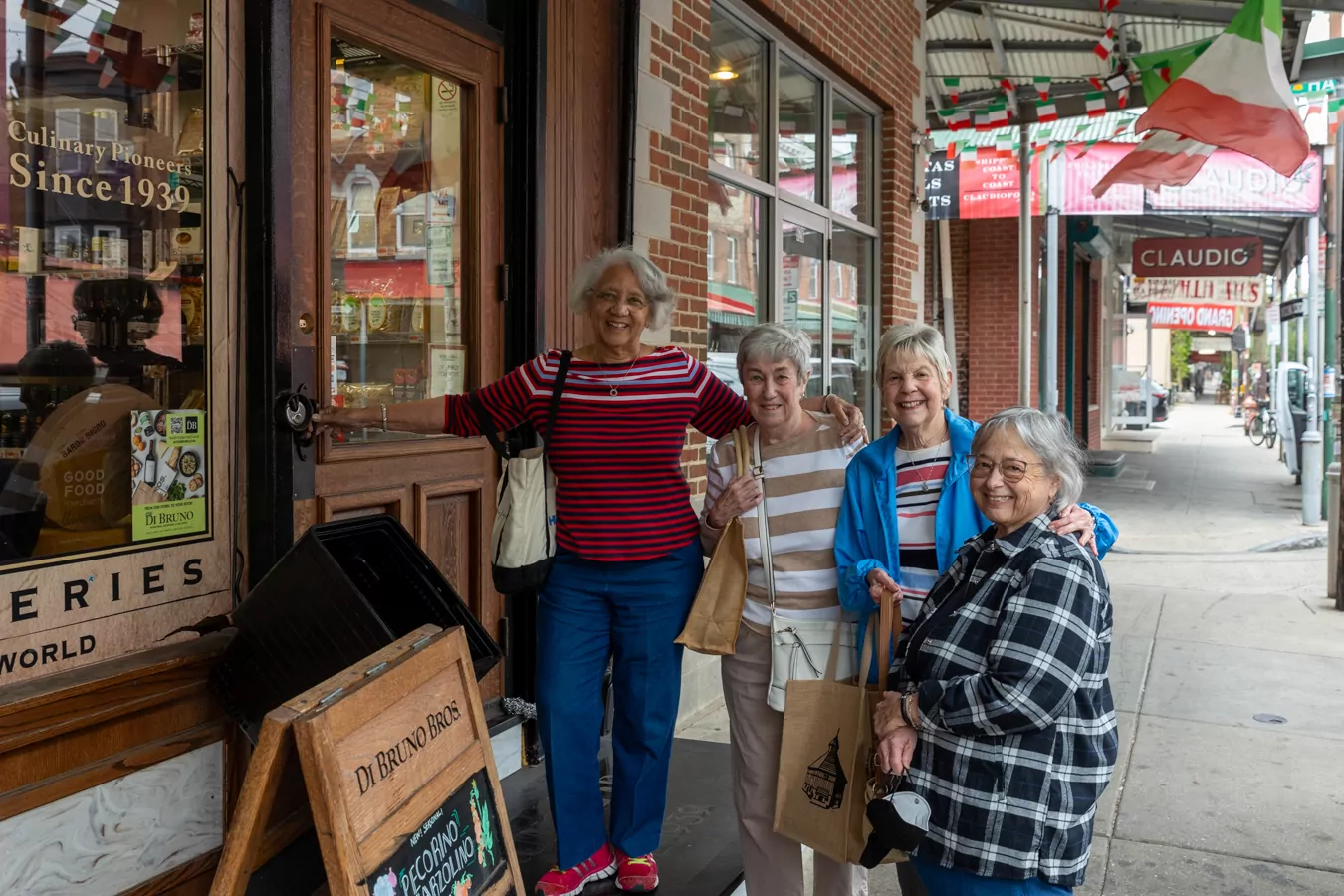Group of smiling women with shopping bags in front of a store in Philadelphia