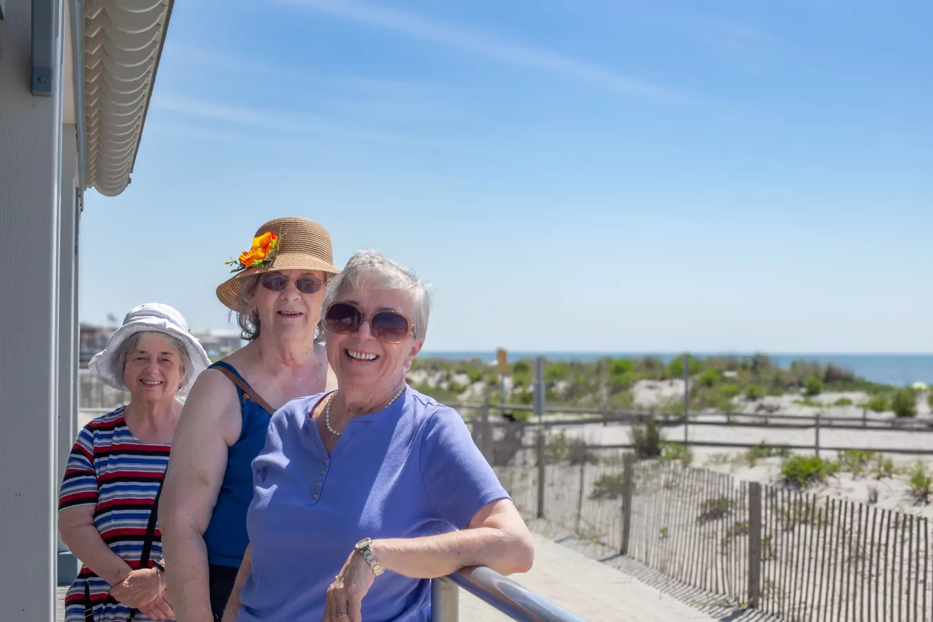 Group of smiling women standing in front of the beach in Ocean City