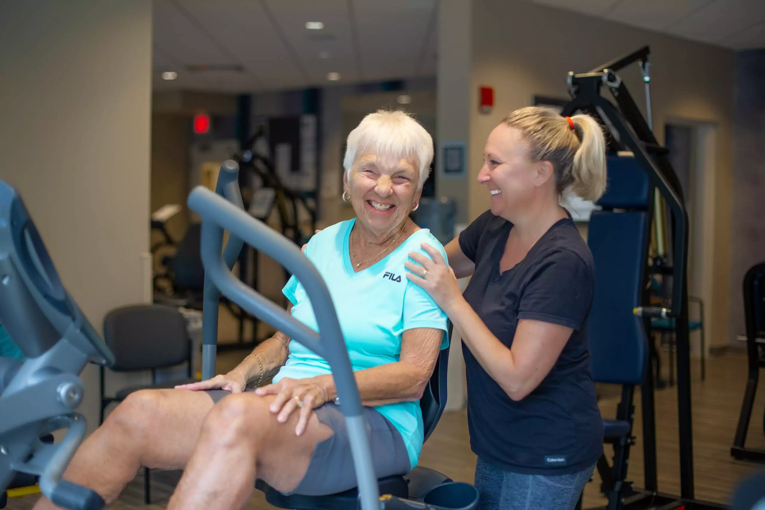 Woman working out in wellness center with staff