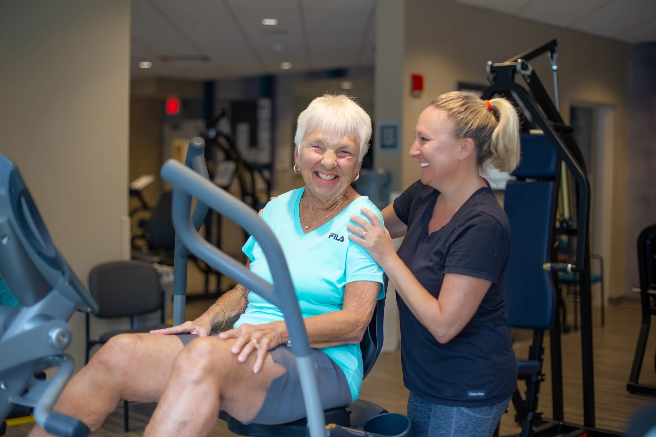 Women in the Wellness Center. Woman working out in wellness center with staff