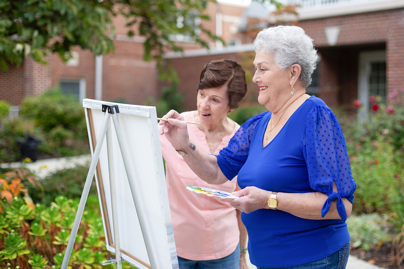 two women painting outdoors