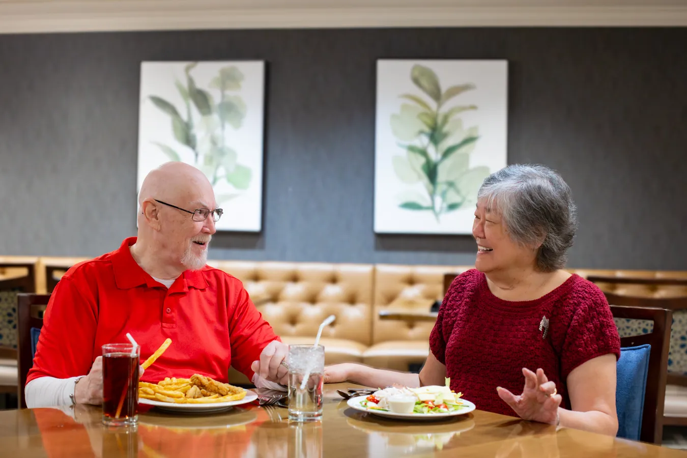 Couple smiling and holding hands while eating their lunch