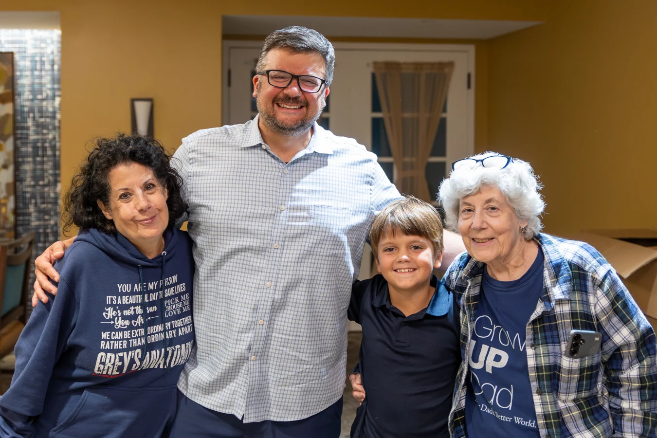 Multi-generational photo of family smiling indoors.