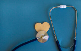 Stethoscope and a wooden heart on a blue background