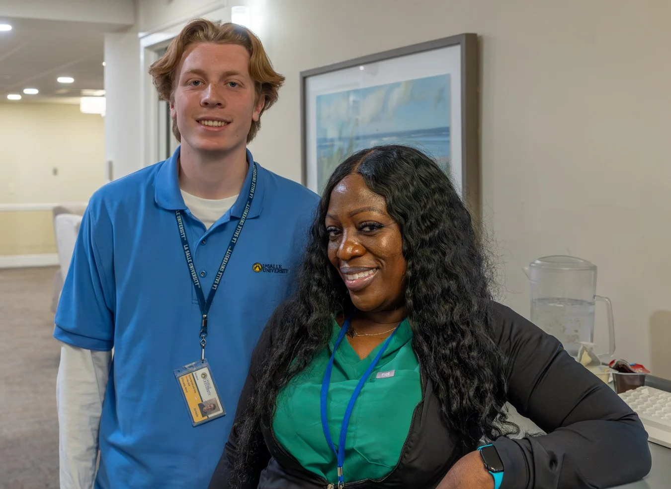 Nursing student and nurse smiling in hallway