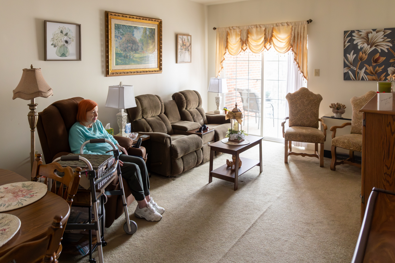 9I4A0346 Woman sitting in well-lit living room.