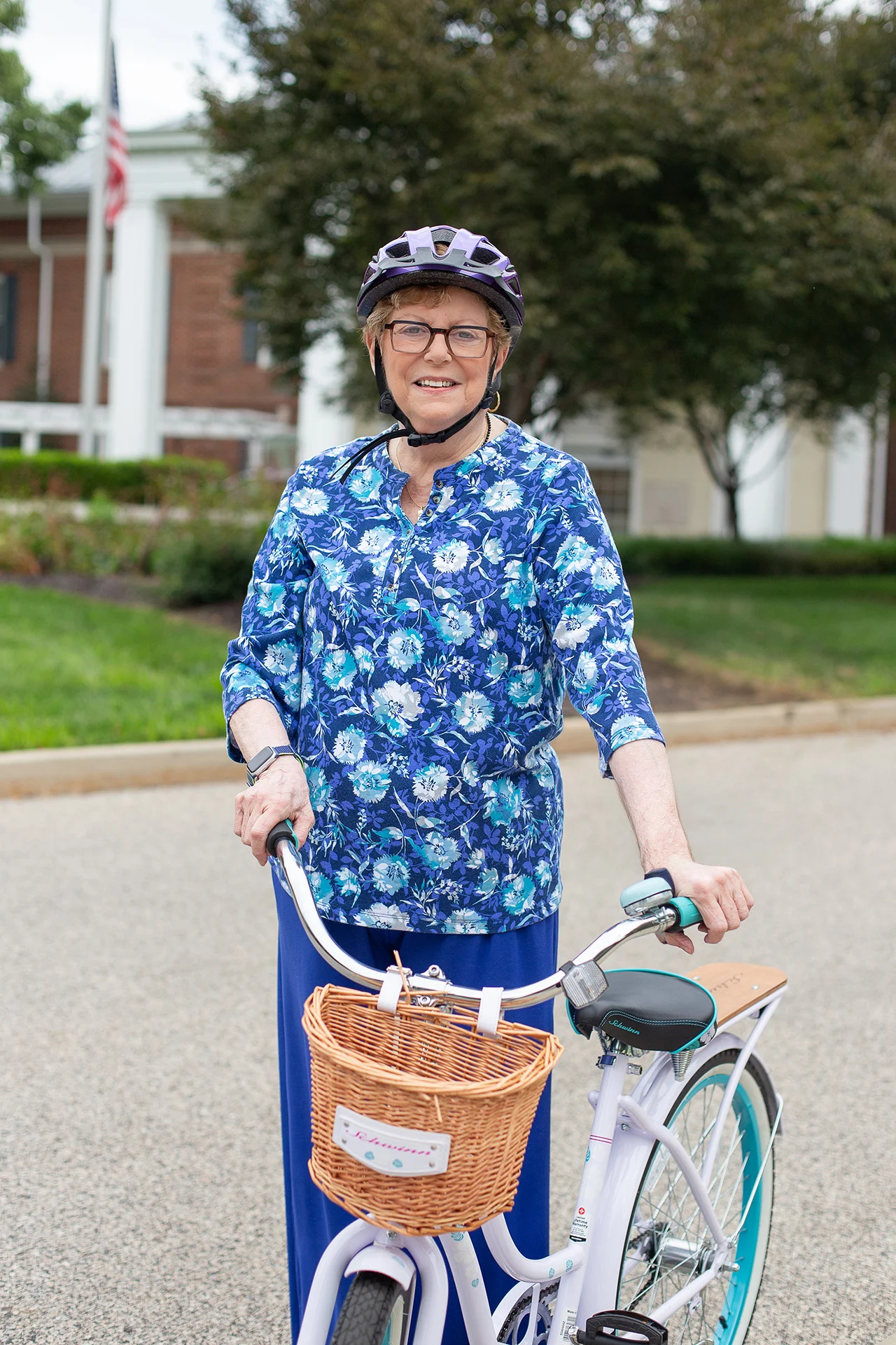 Senior woman with a bicycle. Smiling senior woman in a helmet walking next to her bike.